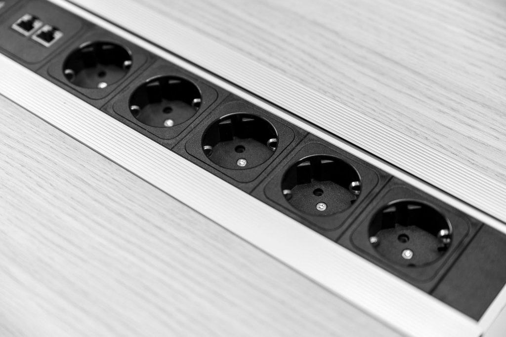 Plano de pormenor de uma calha técnica com tomadas elétricas incorporada na mesa da sala de reuniões do Outglocal Coworking.